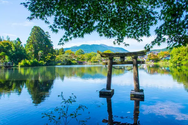 Kinrin Gölü ve Japon kapısı (Torii) Yufu Dağı ve Yufuin, Oita, Kyushu, Japonya 'da mavi gökyüzü arka planı ile