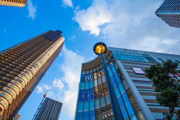 Low angle view of skyscrapers in modern city over blue sky