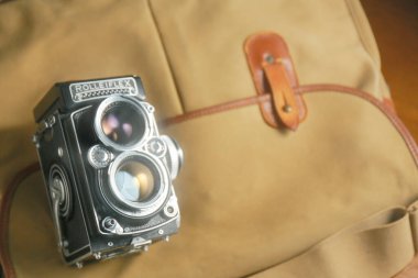 Kahverengi deri çantanın önünde eski çift lensli kamera Rolleiflex