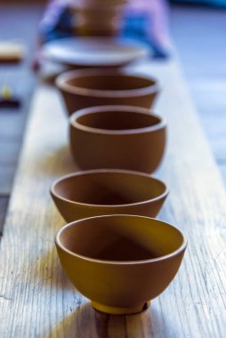 Ahşap masada kil kaseler düzenlenir.