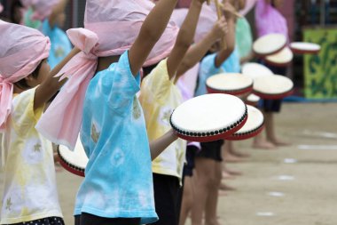 Çocuklar davul ve eşarplarla şarkı söylüyor