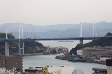 Vinçleri, tekneleri ve binaları olan endüstri limanı, Japonya