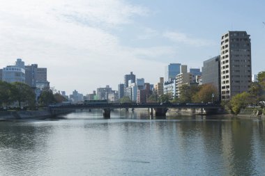 Sakin nehir suyuna yansıyan modern şehir silüeti