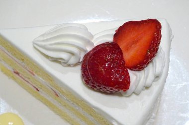 Çilek ve kremalı lezzetli kekin yakın plan çekimi.