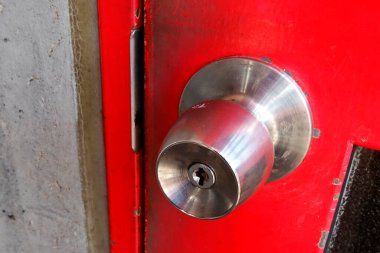 Metal saplı ve eski kırmızı kapılı yakın çekim.  