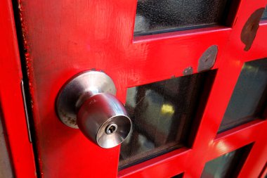 Metal saplı ve eski kırmızı kapılı yakın çekim.    