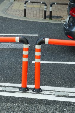 Kentte beyaz çizgileri olan trafik engelleri ve asfalt yol   