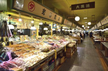 Ürünlerle dolu canlı pazar tezgahlarını keşfediyorlar.