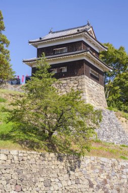 Tepesinde bina olan taştan bir duvar.