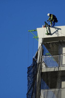 Gökyüzüne karşı çatıda inşaat işçisi