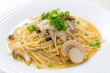 Beyaz tabakta mantarlı ve soslu gurme spagettisinin yakın plan görüntüsü.