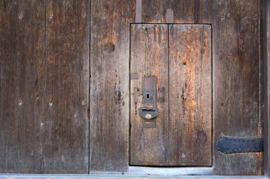 Kırsal kahverengi ahşap duvarda aşınmış ahşap kapı.