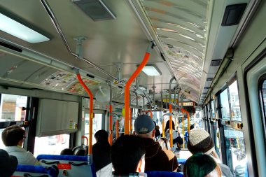Yolcu ve Turuncu korkuluklu bir Japon Kamu Otobüsünün İç Görünümü