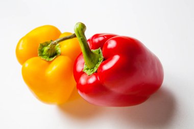 Taze sarı ve kırmızı dolmalık biberler beyaz arka planda izole edilmiş.