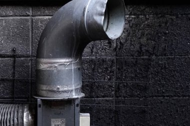 Metal kanal borusu siyah desenli duvar yüzeyine karşı