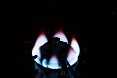 Ocakta yanan gaz ocağı, karanlık arka plan.