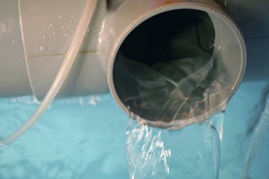 Açık hava, büyük gri plastik borudan akan temiz su.