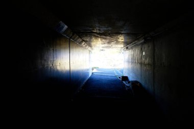 Boş tünel, dışarıda güneş ışığı olan karanlık koridor.    