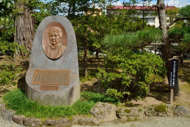 Japon bahçesinde Bronz Portre Plaketi olan Taş Anıt