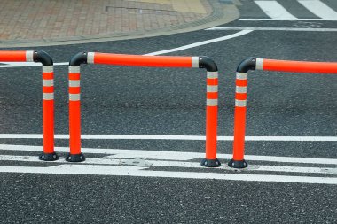Kentte beyaz çizgileri olan trafik engelleri ve asfalt yol   