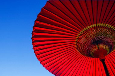 Mavi gökyüzüne karşı kırmızı Japon şemsiyesi 