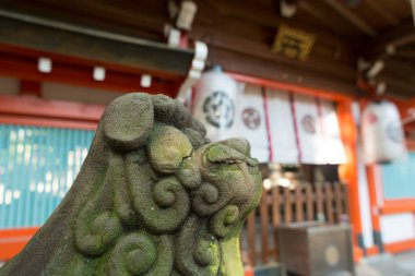 Yıpranmış Japon heykeli bu görkemli yaz akşamında sessiz bir yansıma sunuyor..