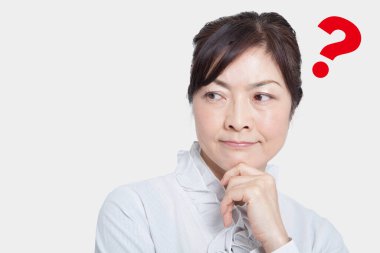 Asyalı olgun kadın soru işaretiyle düşünüyor. 