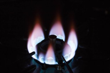 Ocakta yanan gaz ocağı, karanlık arka plan.
