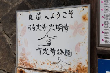 Geleneksel Japon türbesi yakınlarında yıpranmış bilgi panosu