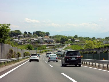 Japonya kırsalında arabalar yolda gidiyor.