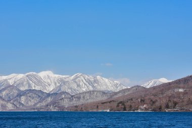 Karlı tepeleri ve gölü olan dağların manzarası 
