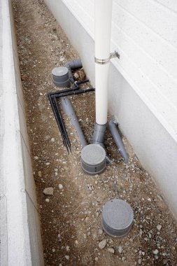 Borular ve drenaj sistemi bina temelinin yanına kurulmuş