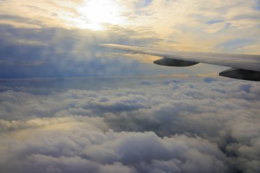 Uçak kanadı ve bulutlu gökyüzü, uçak penceresinden manzara 