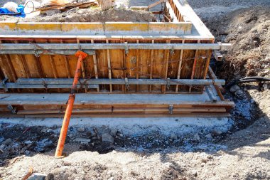 Beton temelleri ve ahşap formları gösteren inşaat alanı