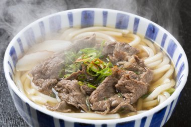 Gurme Asya yemeğinin yakın plan görüntüsü, kasede et olan erişte.    