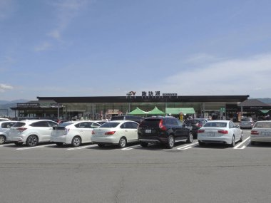 Japonya 'daki alışveriş merkezinin yakınındaki arabalarla dolu otopark.        