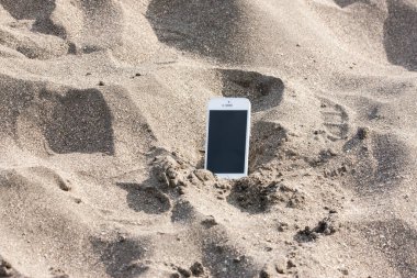 Deniz kıyısındaki kumsalda telefon