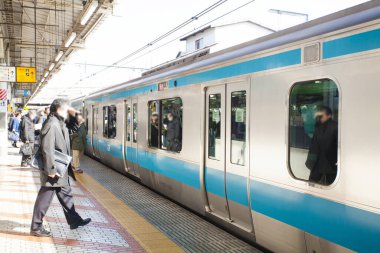Modern yolcuların Japonya 'daki tren istasyonunda çekilmiş sokak fotoğrafı.