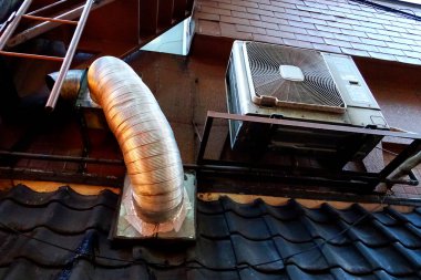 Klima ünitesi çatı kiremitlerinin yakınındaki duvara monte edildi.