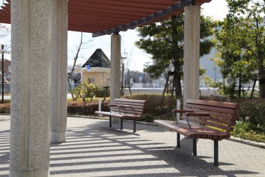 Parkta Beton ve Metal Pergola Altında İki Boş Ahşap Benç