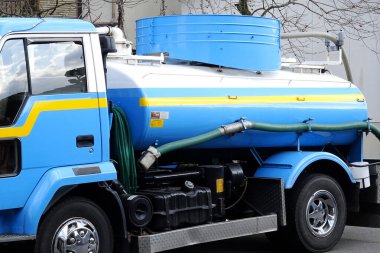 Binanın yakınına park edilmiş mavi su tankeri kamyonu