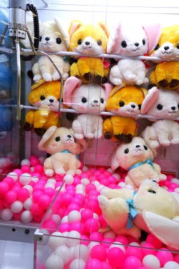 Pençe makinesinin içinde düzenlenmiş renkli pelüş oyuncaklar