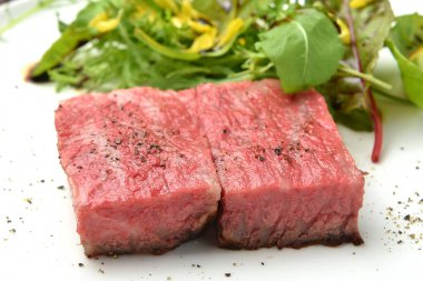 Tabağında otlar olan taze ve lezzetli biftekler.