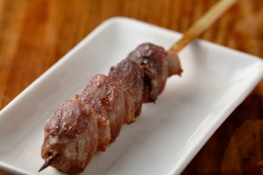 Ahşap şiş ve kızarmış et parçaları.