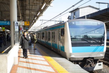 Japonya. Tren ve yolcularla dolu tren istasyonu.  