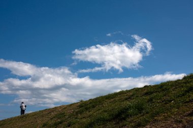 Yeşil tepede yürüyen bir adamın dikiz görüntüsü 