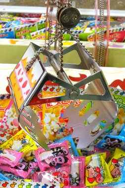 Parlak metal pençe altında renkli şeker paketleri