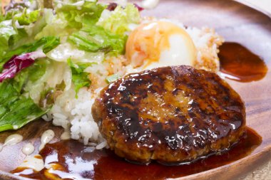 Et pirzolası, pirinç ve salata ile bir tabak yemek.