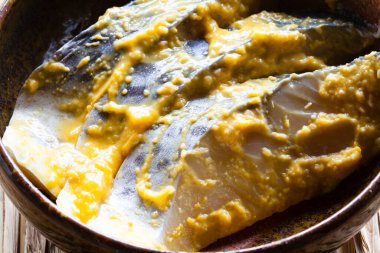 Beyaz tabakta soslu marine edilmiş uskumru balığı. 