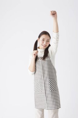 Stüdyoda poz veren önlüklü Japon kadın anaokulu öğretmeni.